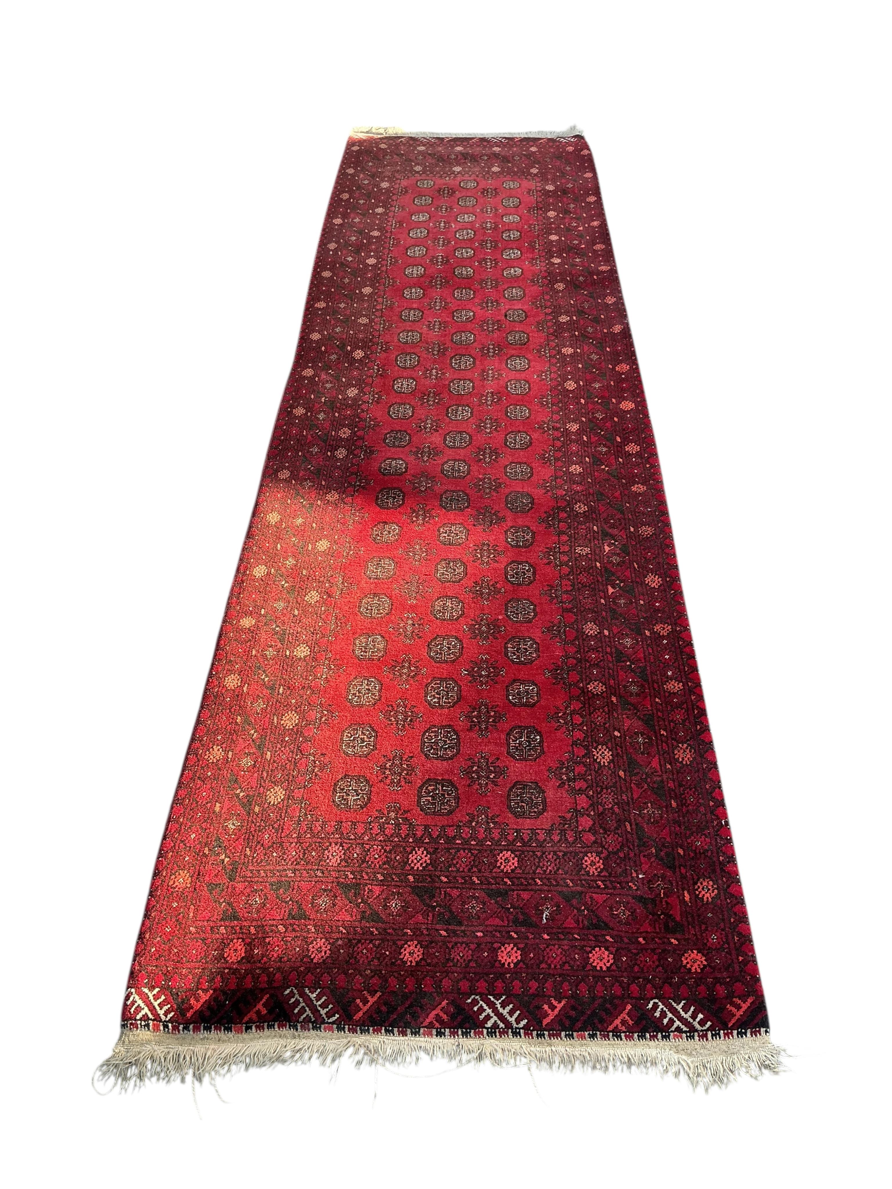 A Bokhara red ground runner, 290 x 80cm